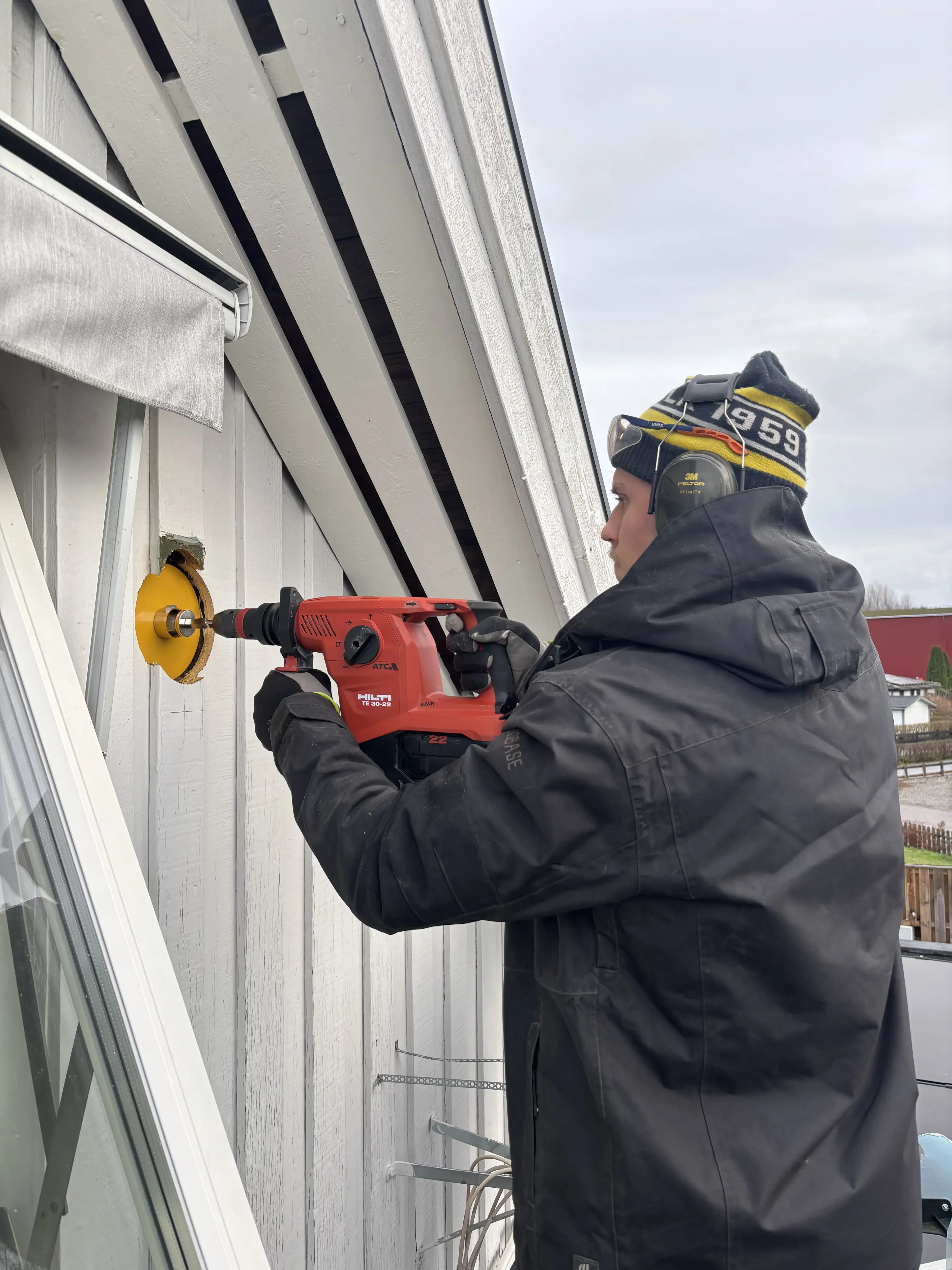 Tekniker borrar hålet i ytterväggen för installation av Mini FTX