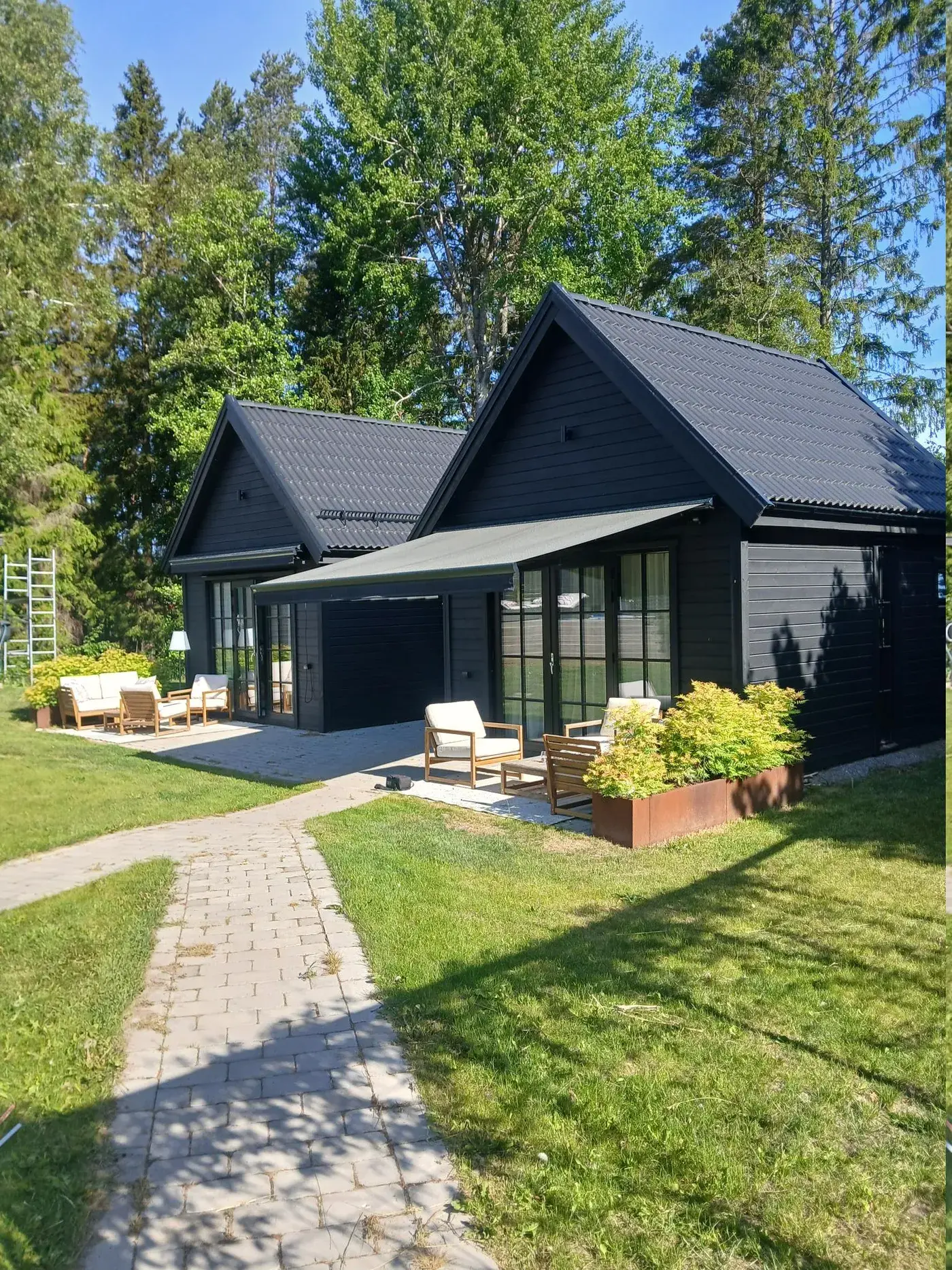 Modernt svart attefallshus med Air Pro V2.0-ventilation installerad genom ytterväggen
